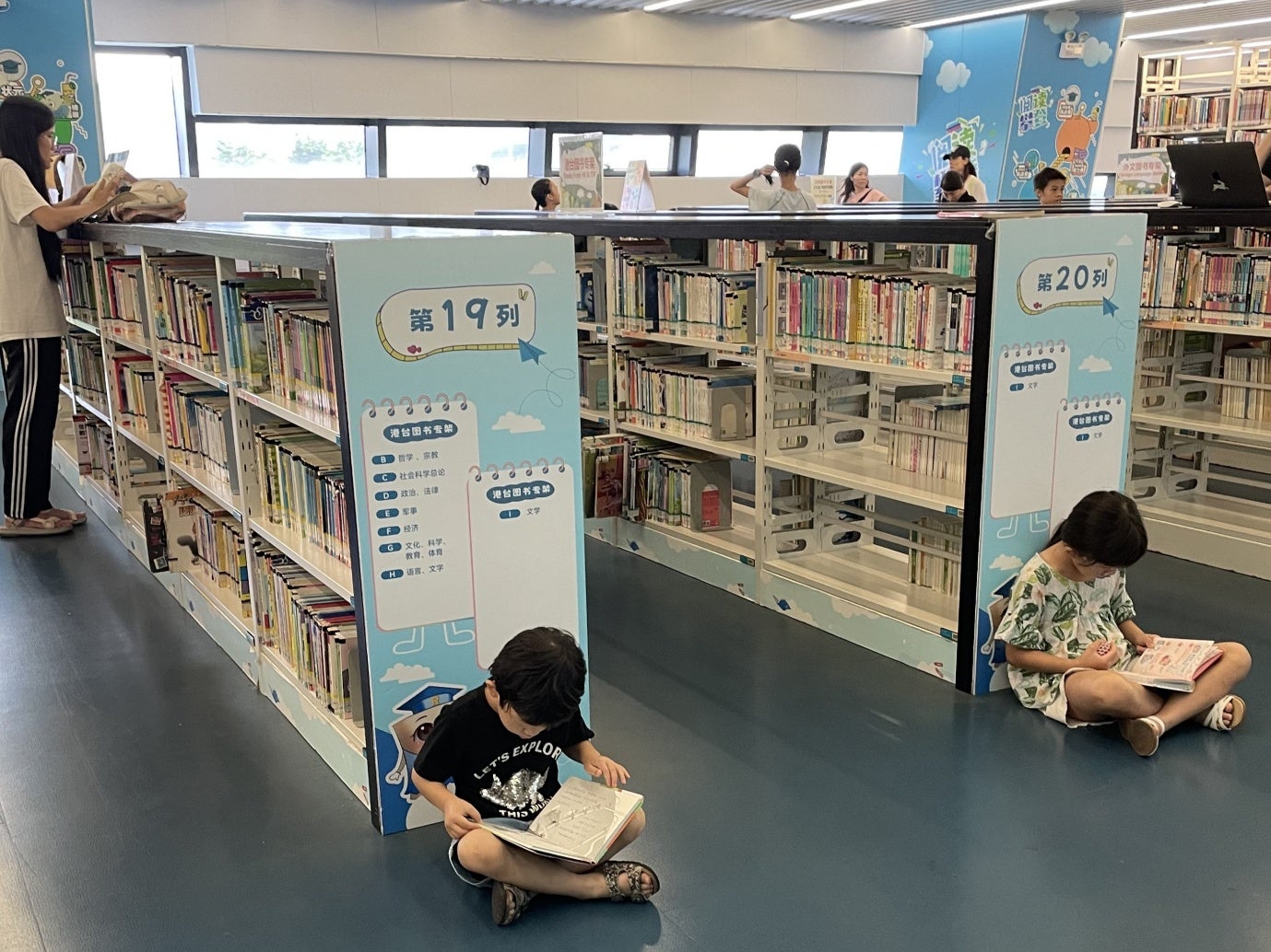 休日は多くの人が訪れる広州図書館で日本語の本を読む姉弟
